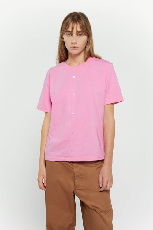 Model wearing the pink Buttons Shirt Tee with brown trousers, front view