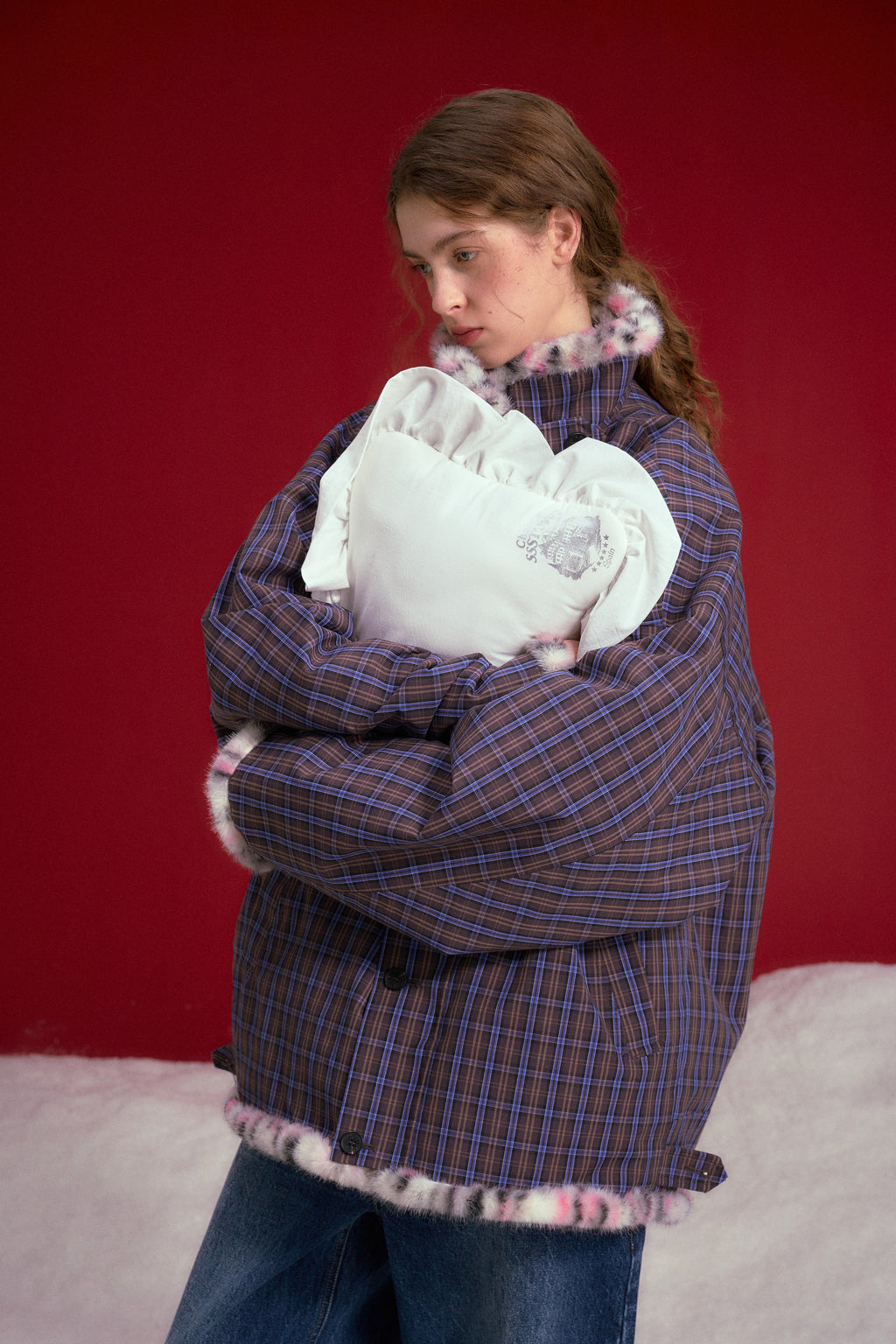 Reversible Leopard Print Checkered Coat worn on a female model holding a pillow, check side out, waist-up view.