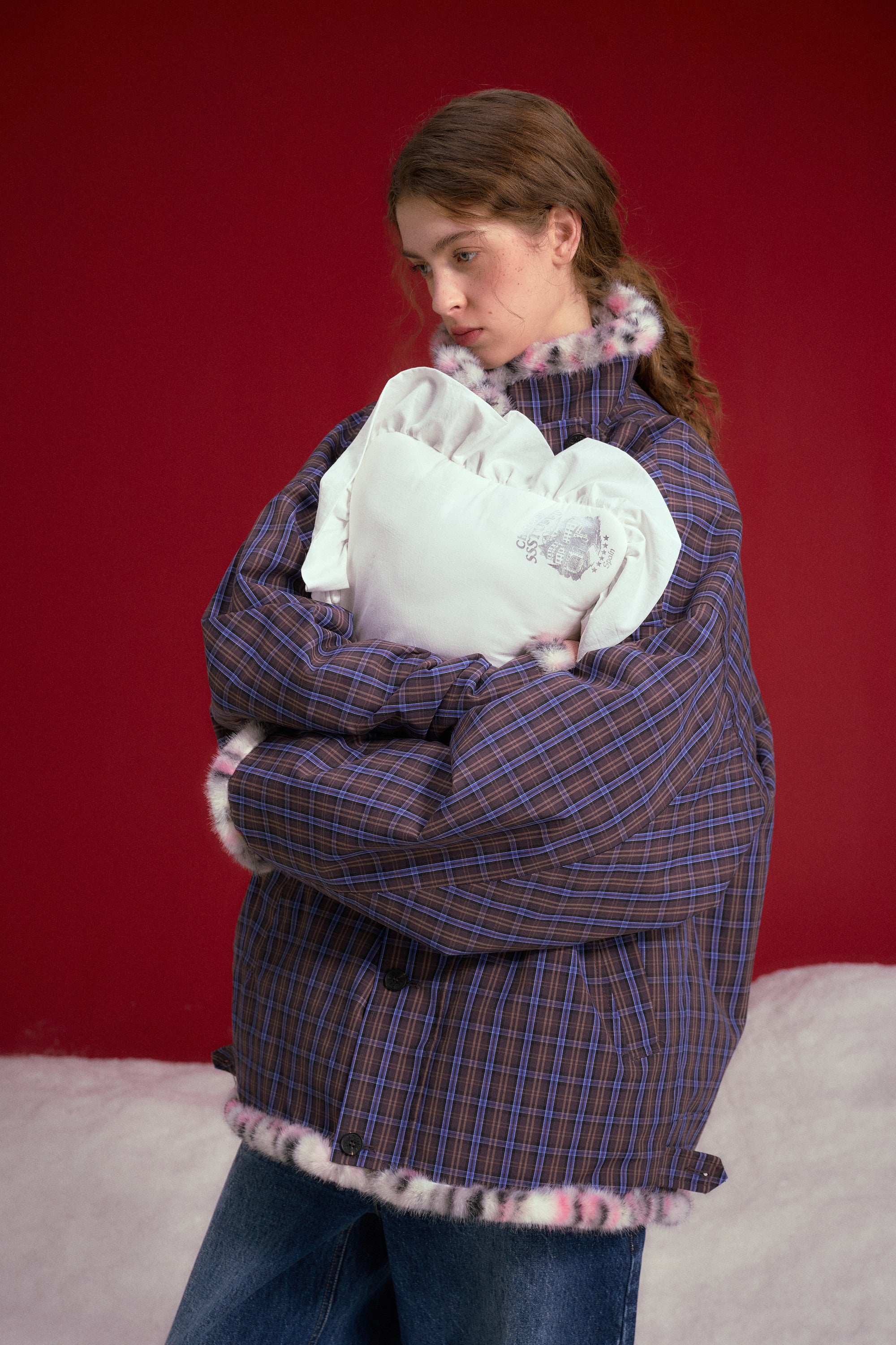 Reversible Leopard Print Checkered Coat worn on a female model holding a pillow, check side out, waist-up view.