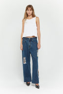 Medium blue relaxed fit jeans with embroidered and printed patches and white lace waist tie