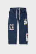 Medium blue relaxed fit jeans with embroidered and printed patches and white lace waist tie