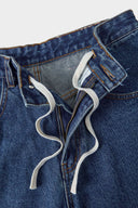 Medium blue relaxed fit jeans with embroidered and printed patches and white lace waist tie