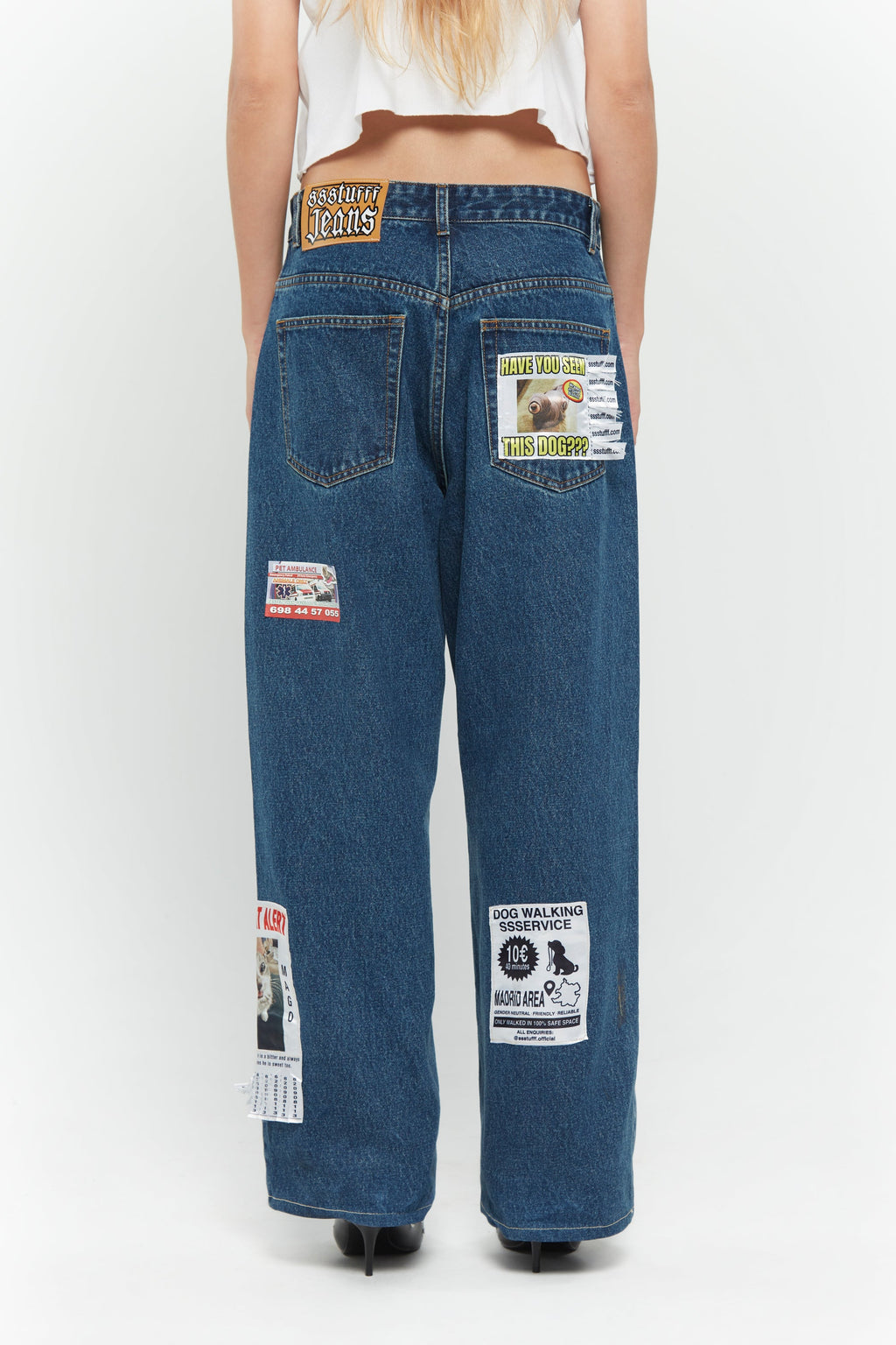 Medium blue relaxed fit jeans with embroidered and printed patches and white lace waist tie
