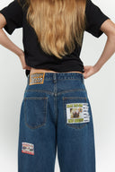 Medium blue relaxed fit jeans with embroidered and printed patches and white lace waist tie