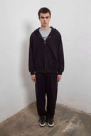 Black zip-up hoodie with embroidered mini logo on back and black sweatpants with mini logo detail and drawstring waist