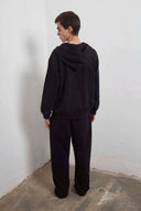 Black zip-up hoodie with embroidered mini logo on back and black sweatpants with mini logo detail and drawstring waist