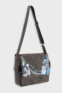Messenger bag with UV printed charm graphics, adjustable strap, and keychain details