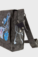 Messenger bag with UV printed charm graphics, adjustable strap, and keychain details