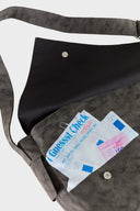 Messenger bag with UV printed charm graphics, adjustable strap, and keychain details