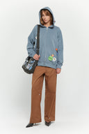 Messenger bag with UV printed charm graphics, adjustable strap, and keychain details