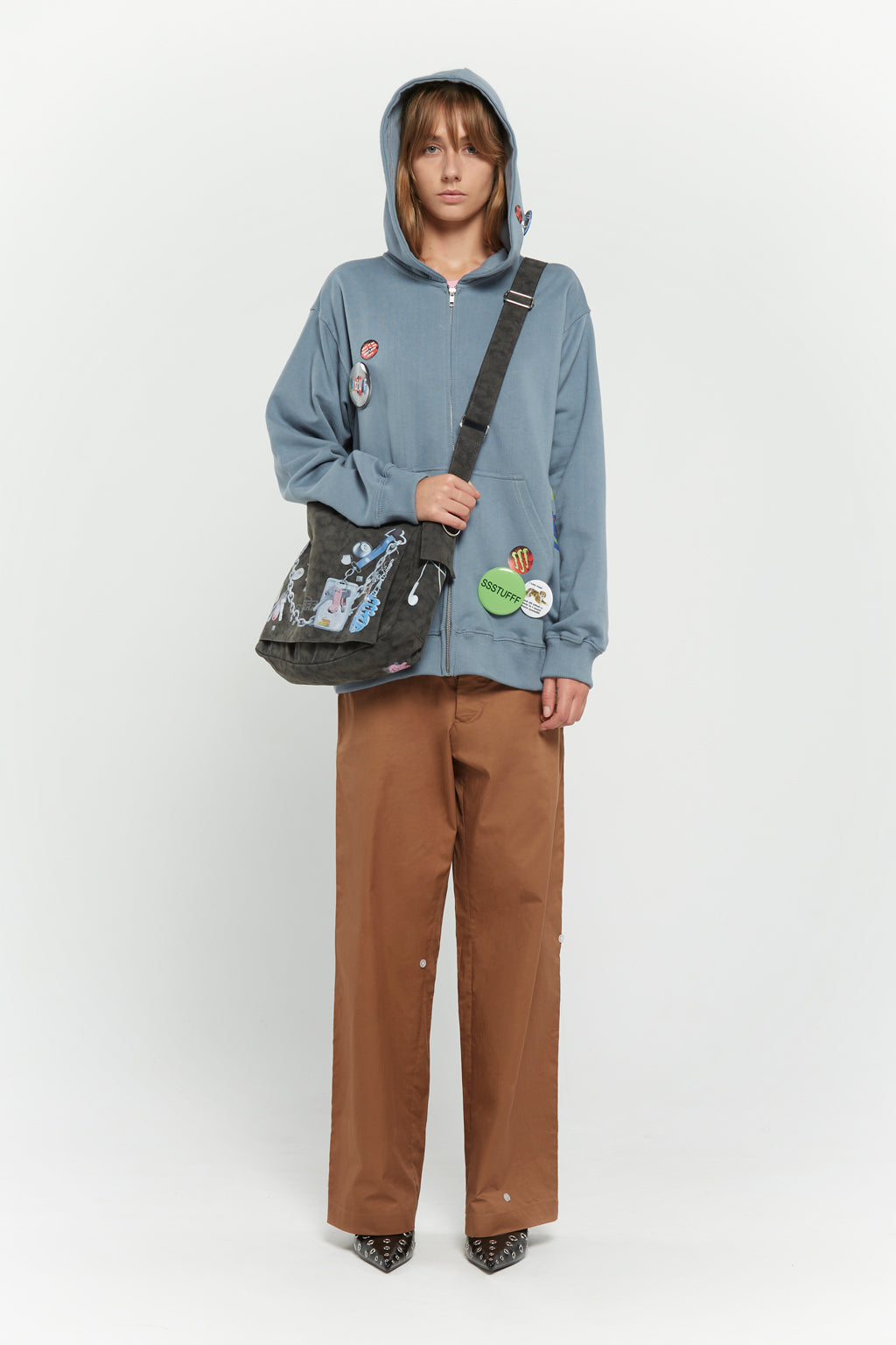 Messenger bag with UV printed charm graphics, adjustable strap, and keychain details