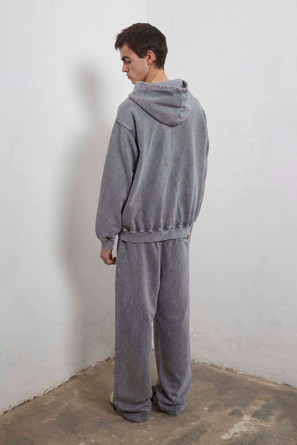Grey zip-up hoodie with embroidered mini logo on back and black sweatpants with mini logo detail and drawstring waist