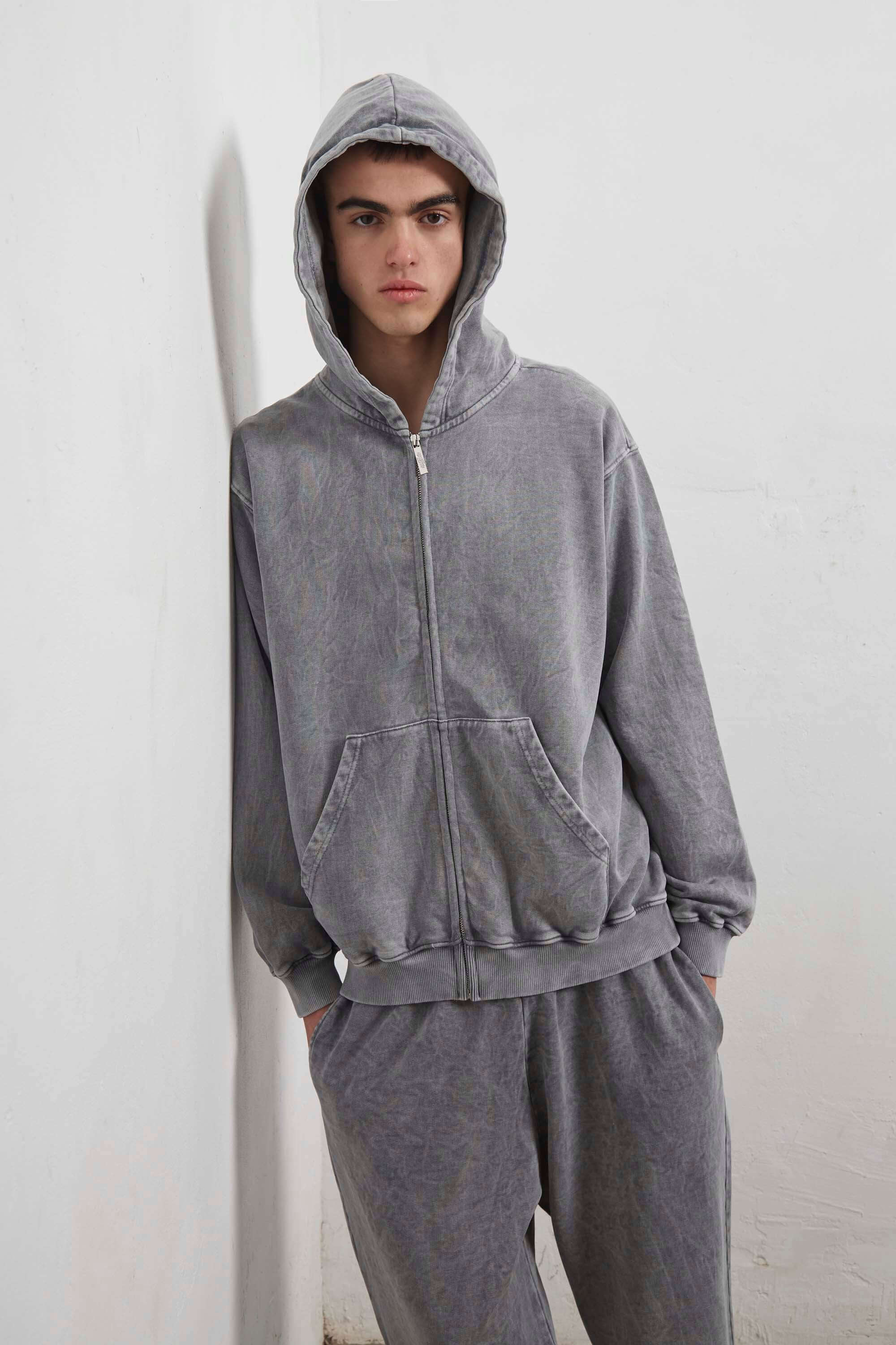 Grey zip-up hoodie with embroidered mini logo on the back
