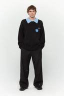 Black knit sweater designed to look like a shirt, with blue collar and attachable name tag and employee of the month pin