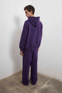 Purple zip-up hoodie with embroidered mini logo on back and black sweatpants with mini logo detail and drawstring waist