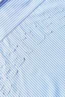 Blue short-sleeved button-up shirt with a pattern of stars and stripes on the chest area.