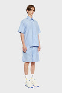 Blue short-sleeved button-up shirt with a pattern of stars and stripes on the chest area.