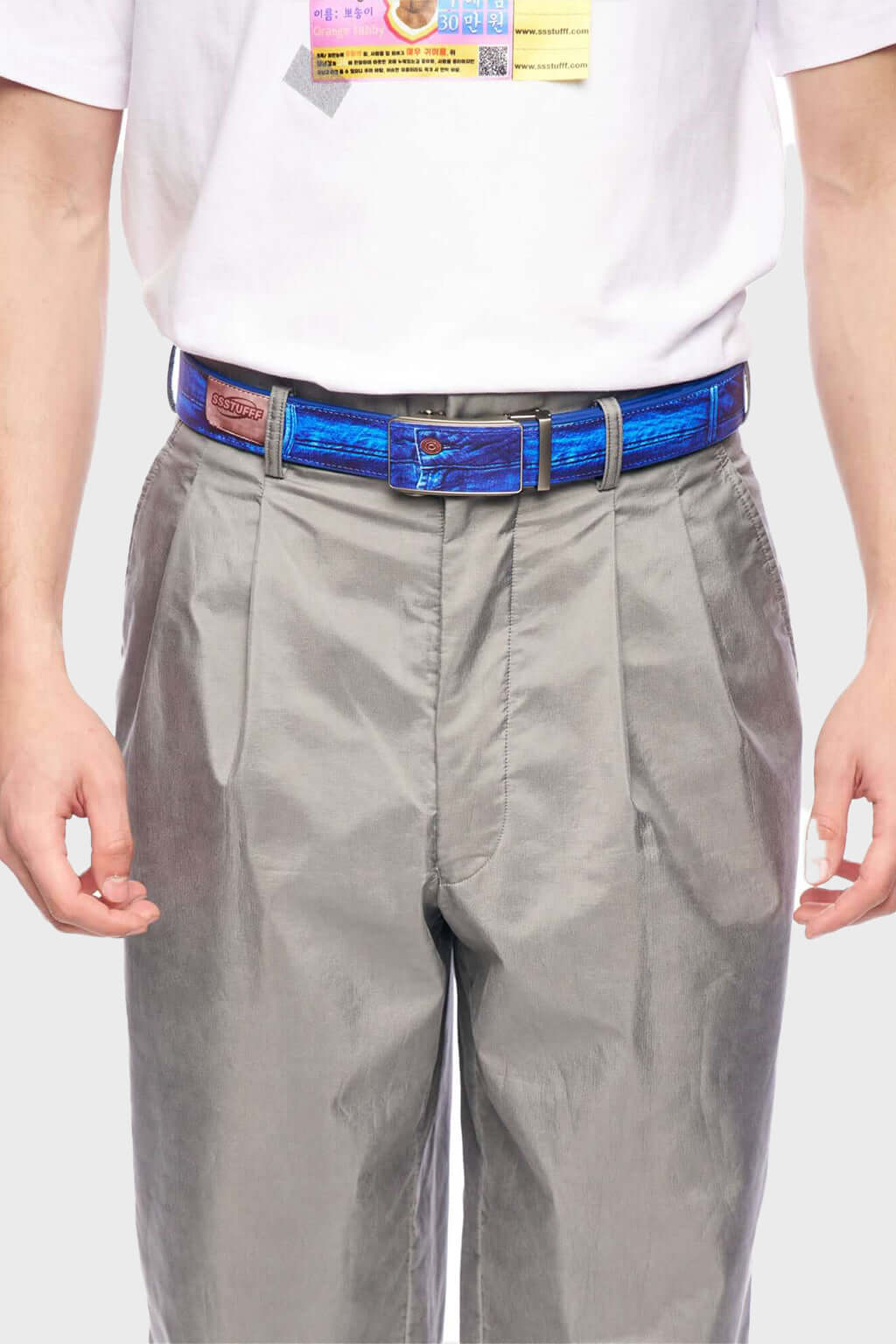 A printed PU leather belt with a slideable adjust and button release, featuring a denim emulated print.