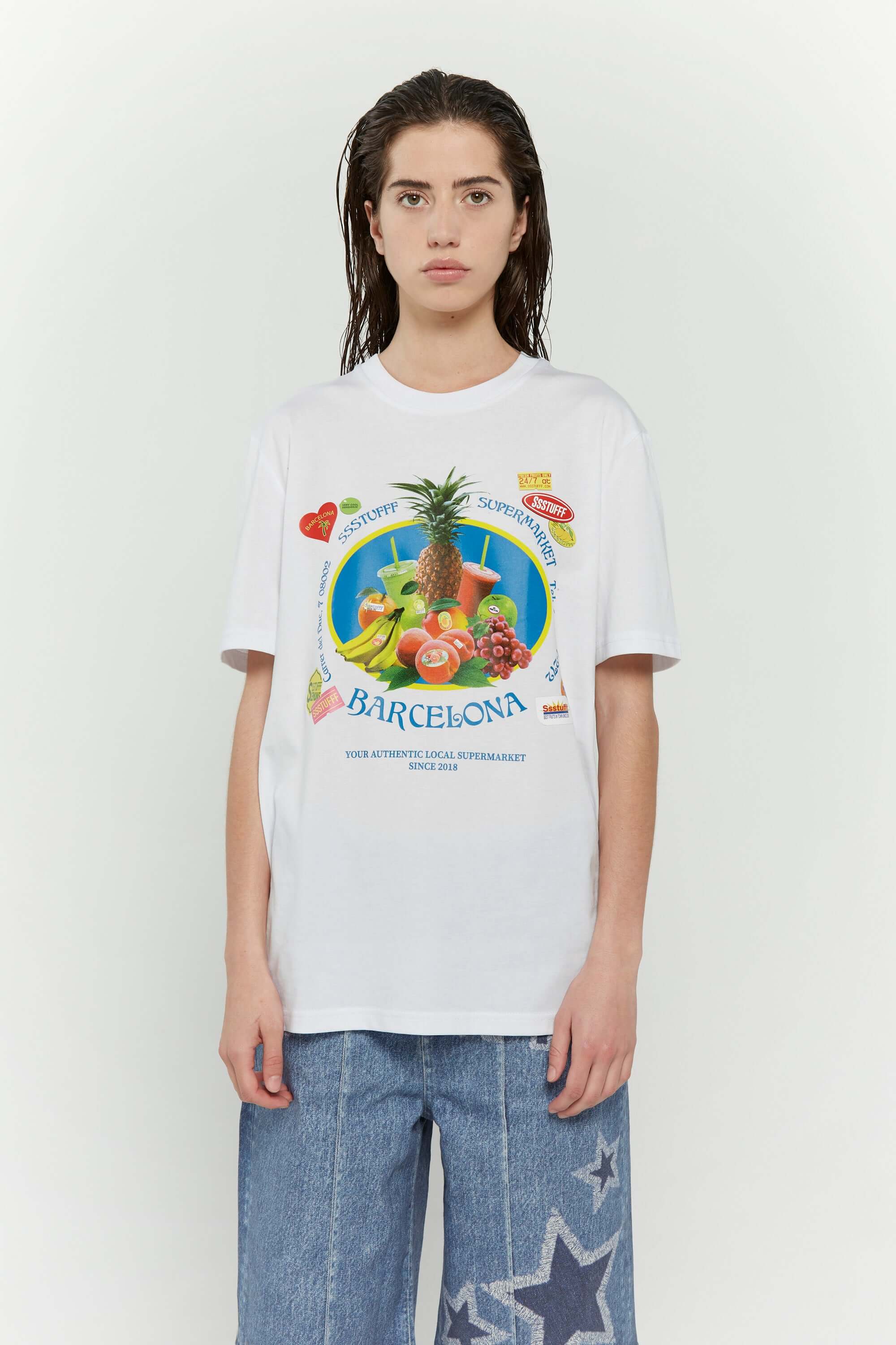 White t-shirt with various colorful fruits graphic, Barcelona text, and scented print that smells like sweet banana
