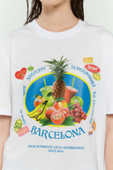 White t-shirt with various colorful fruits graphic, Barcelona text, and scented print that smells like sweet banana