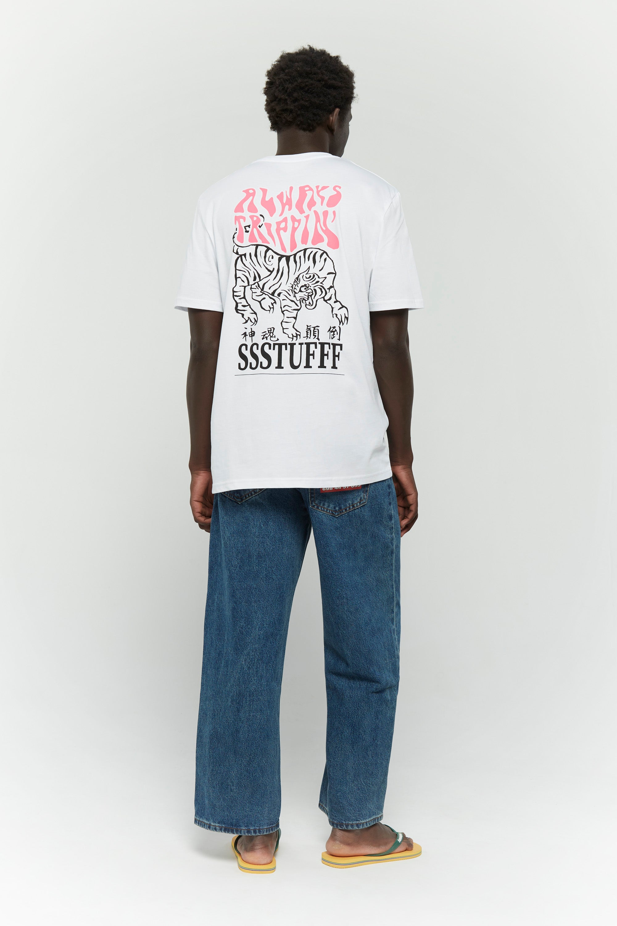 White t-shirt with UV reactive tiger graphic and 'Always Trippin' text that changes color in sunlight