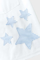 A pair of white shorts with blue striped stars and patchwork details.