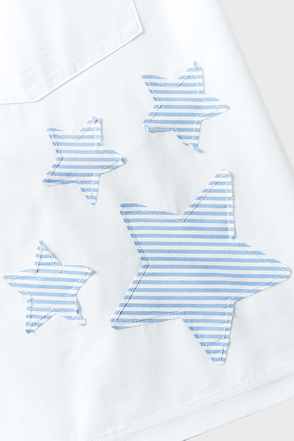 A pair of white shorts with blue striped stars and patchwork details.