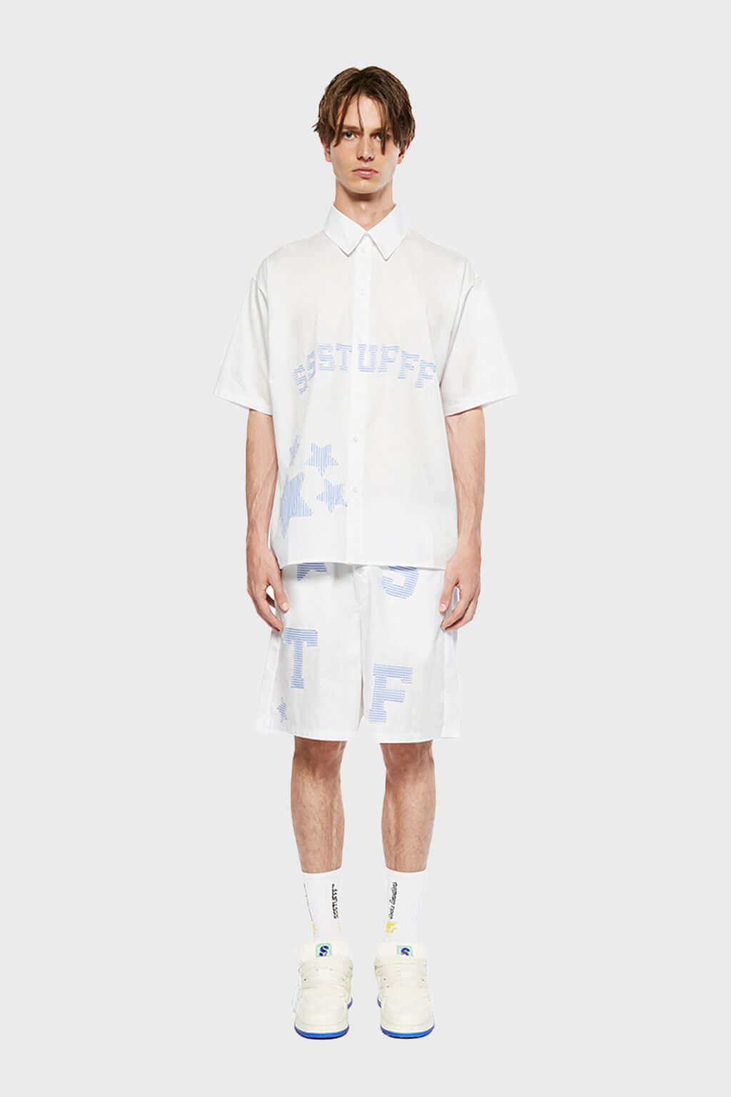 A pair of white shorts with blue striped stars and patchwork details.