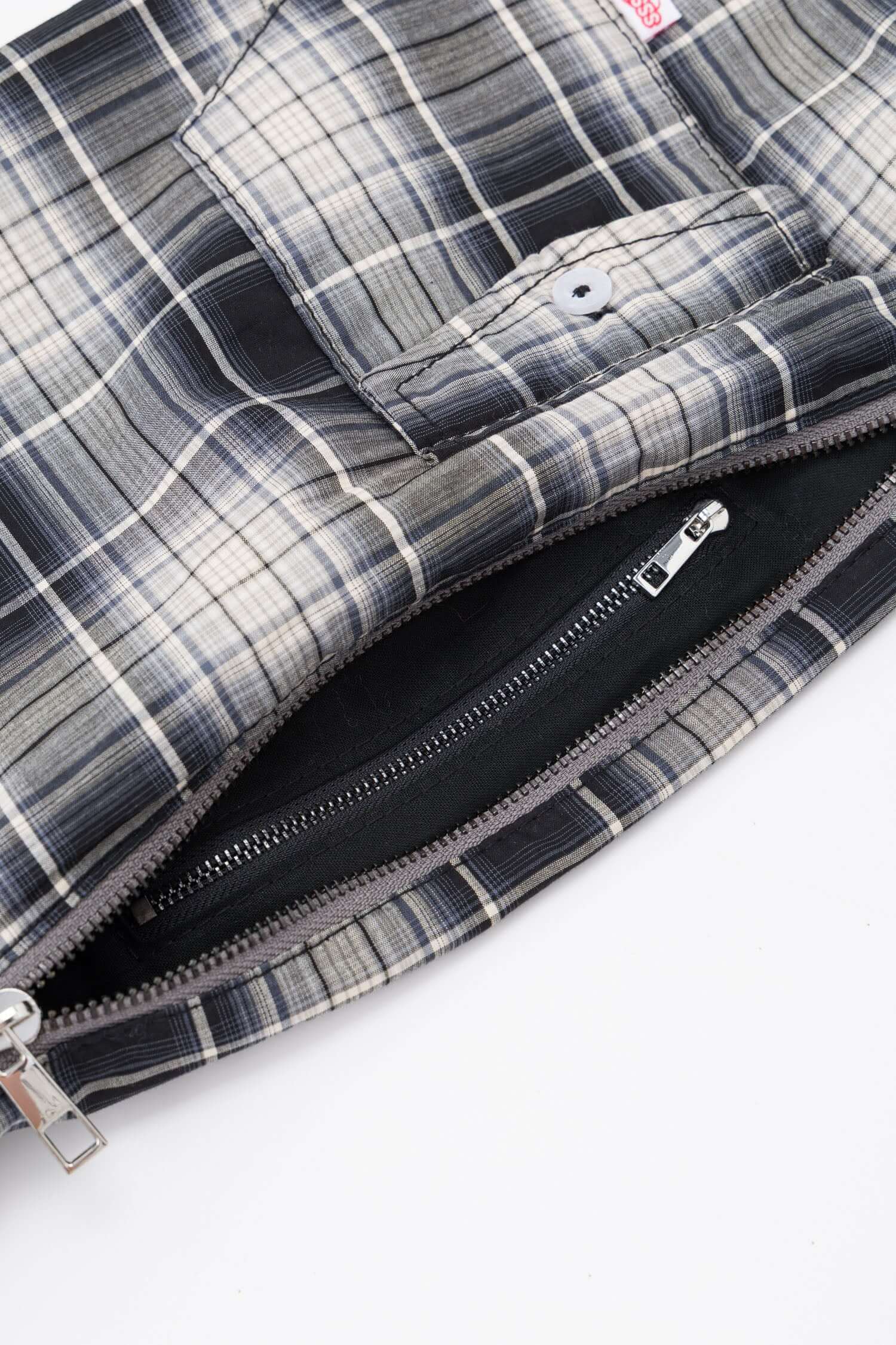 Black and white checked croissant-shaped mini bag with shirt texture and adjustable sleeve handles for shoulder or crossbody wear