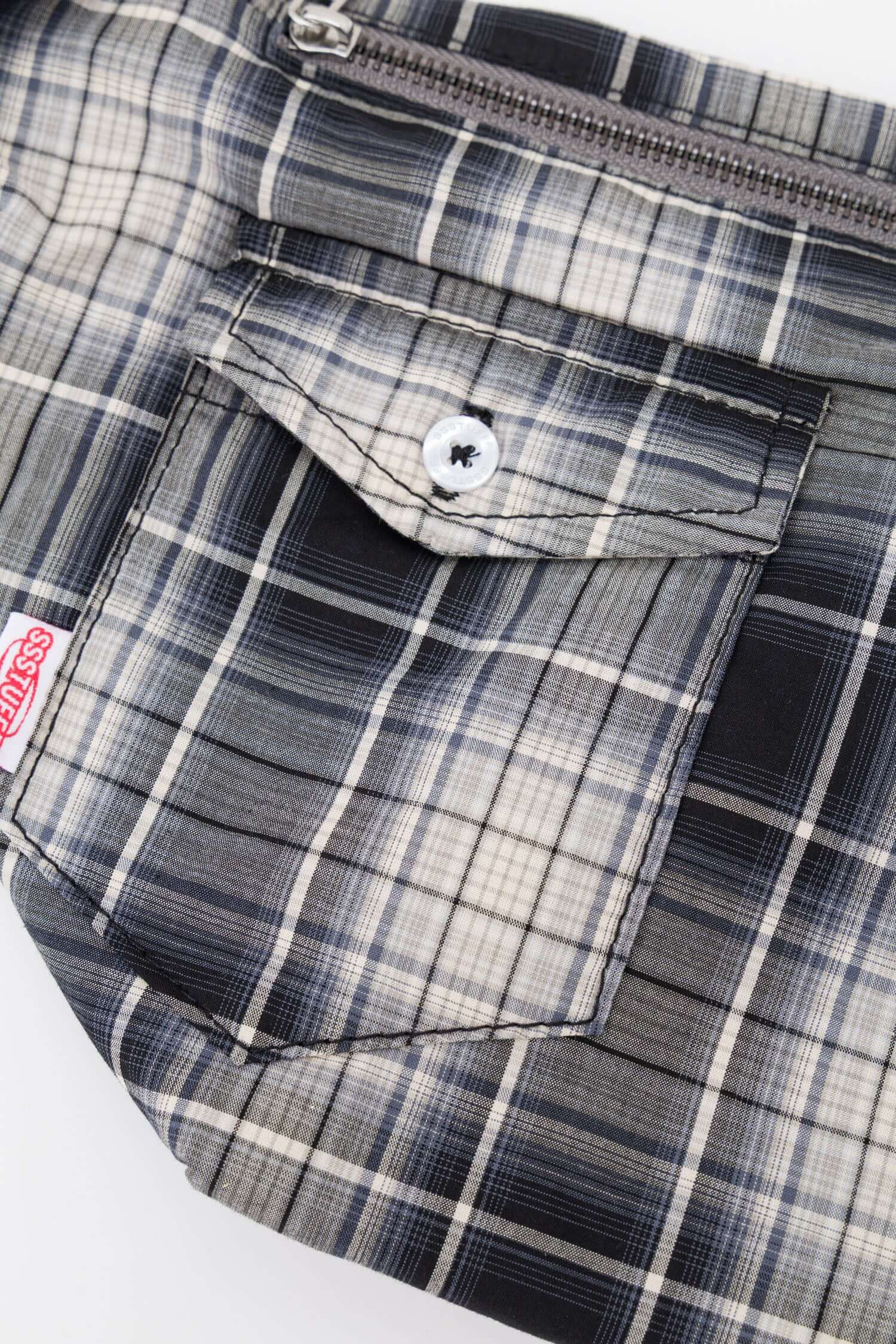 Black and white checked croissant-shaped mini bag with shirt texture and adjustable sleeve handles for shoulder or crossbody wear