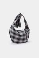 Black and white checked croissant-shaped bag with shirt texture and adjustable sleeve handles for shoulder or crossbody wear