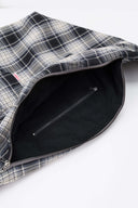 Black and white checked croissant-shaped bag with shirt texture and adjustable sleeve handles for shoulder or crossbody wear