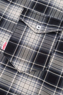 Black and white checked croissant-shaped bag with shirt texture and adjustable sleeve handles for shoulder or crossbody wear