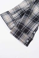 Black and white checked croissant-shaped bag with shirt texture and adjustable sleeve handles for shoulder or crossbody wear