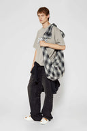 Black and white checked croissant-shaped bag with shirt texture and adjustable sleeve handles for shoulder or crossbody wear