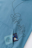 Blue hoodie with digital print of classic headphones and MP3 player extending from hood to front pocket