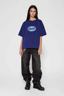 Black wash denim jeans with embroidered keychain, carabiner, and earphone charm details, and pin embroidery on ankle