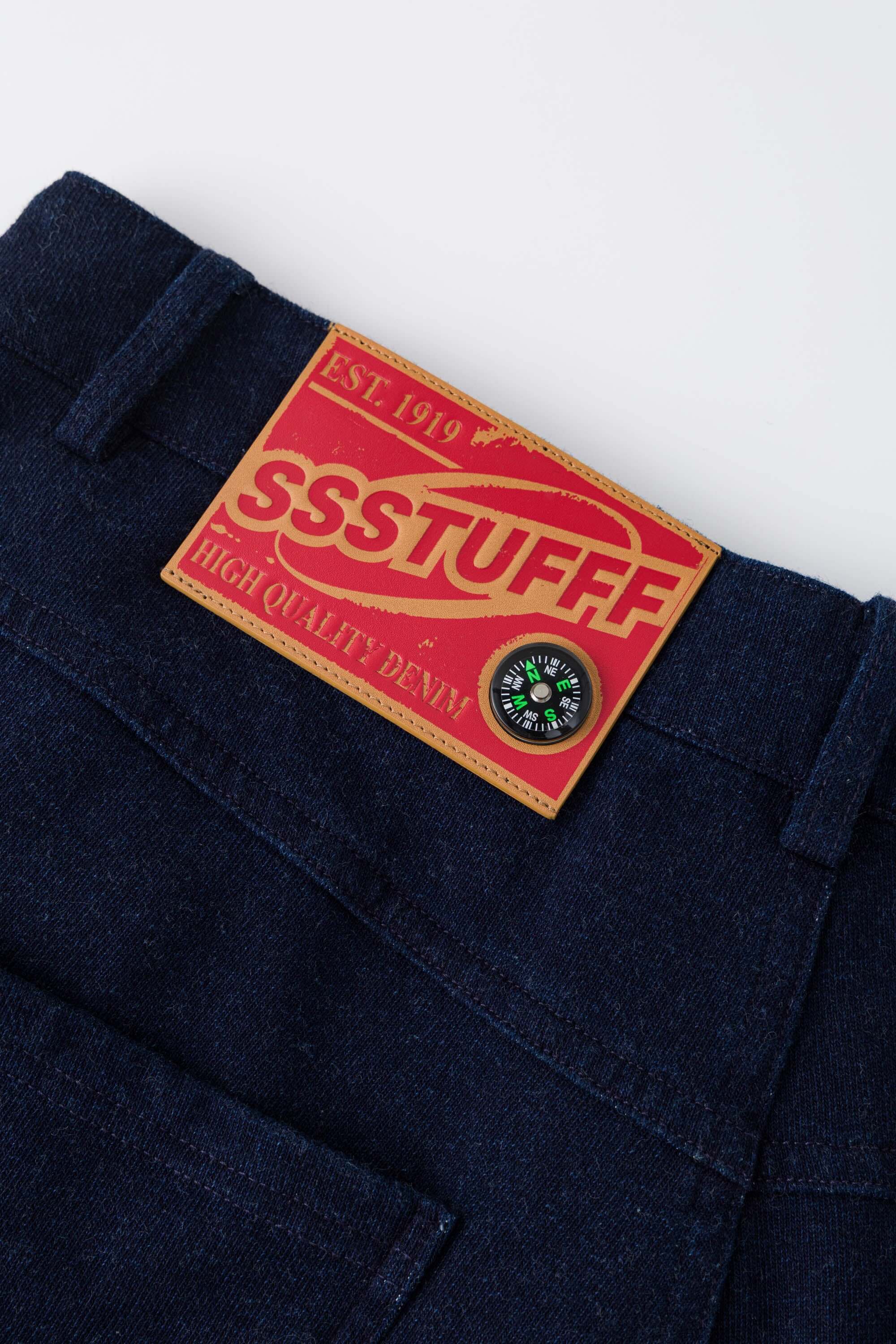 Denim-effect sweatpants with gothic STF embroidery, custom SSSTUFFF metal button, and leather patch with functional compass
