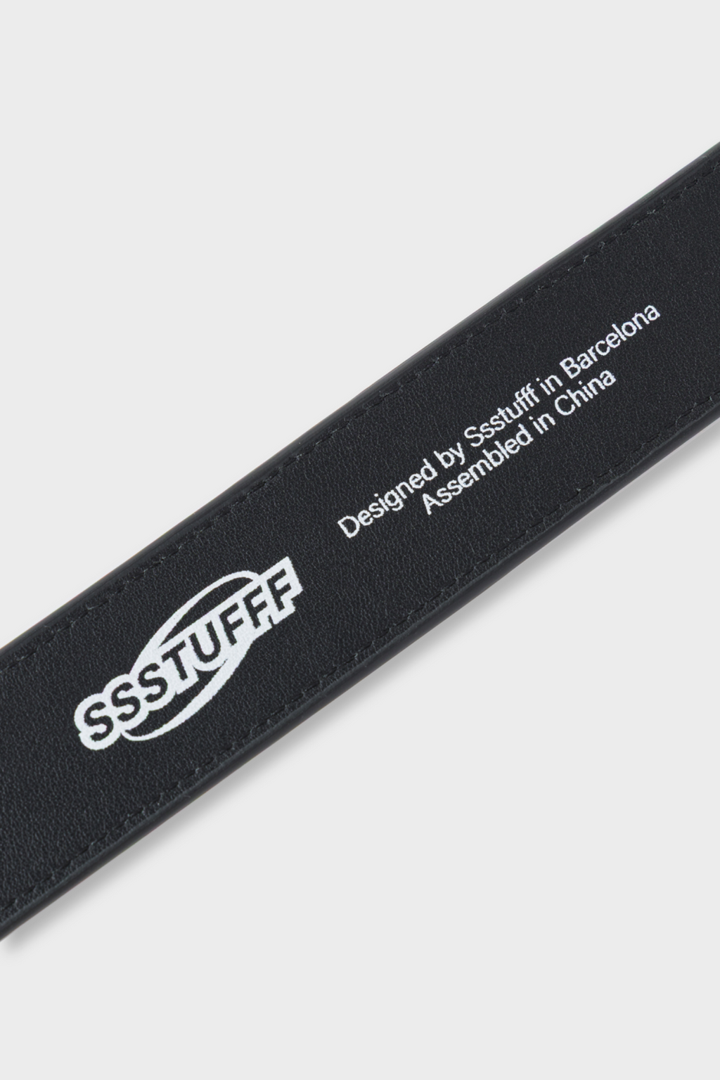Black leather belt featuring a red and white square buckle designed to resemble a classic iPod Shuffle music player.