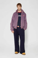 Reversible jacket with burgundy and grey micro-check pattern on one side and purple fleece on reverse