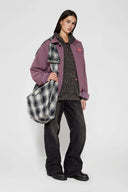 Reversible jacket with burgundy and grey micro-check pattern on one side and purple fleece on reverse