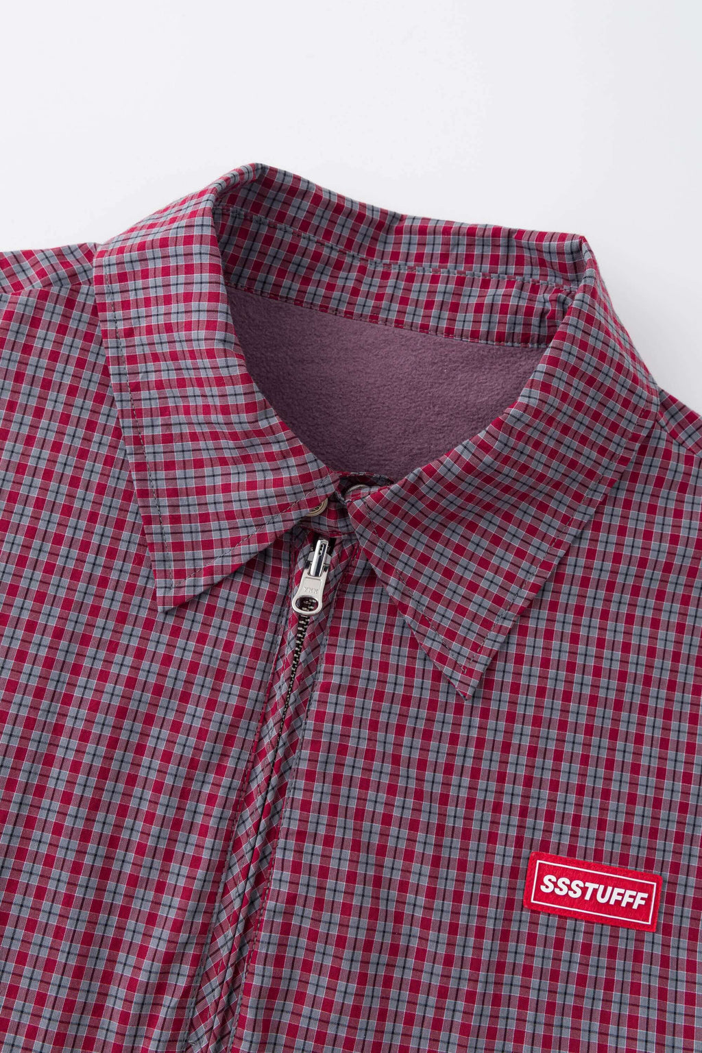 Reversible jacket with burgundy and grey micro-check pattern on one side and purple fleece on reverse