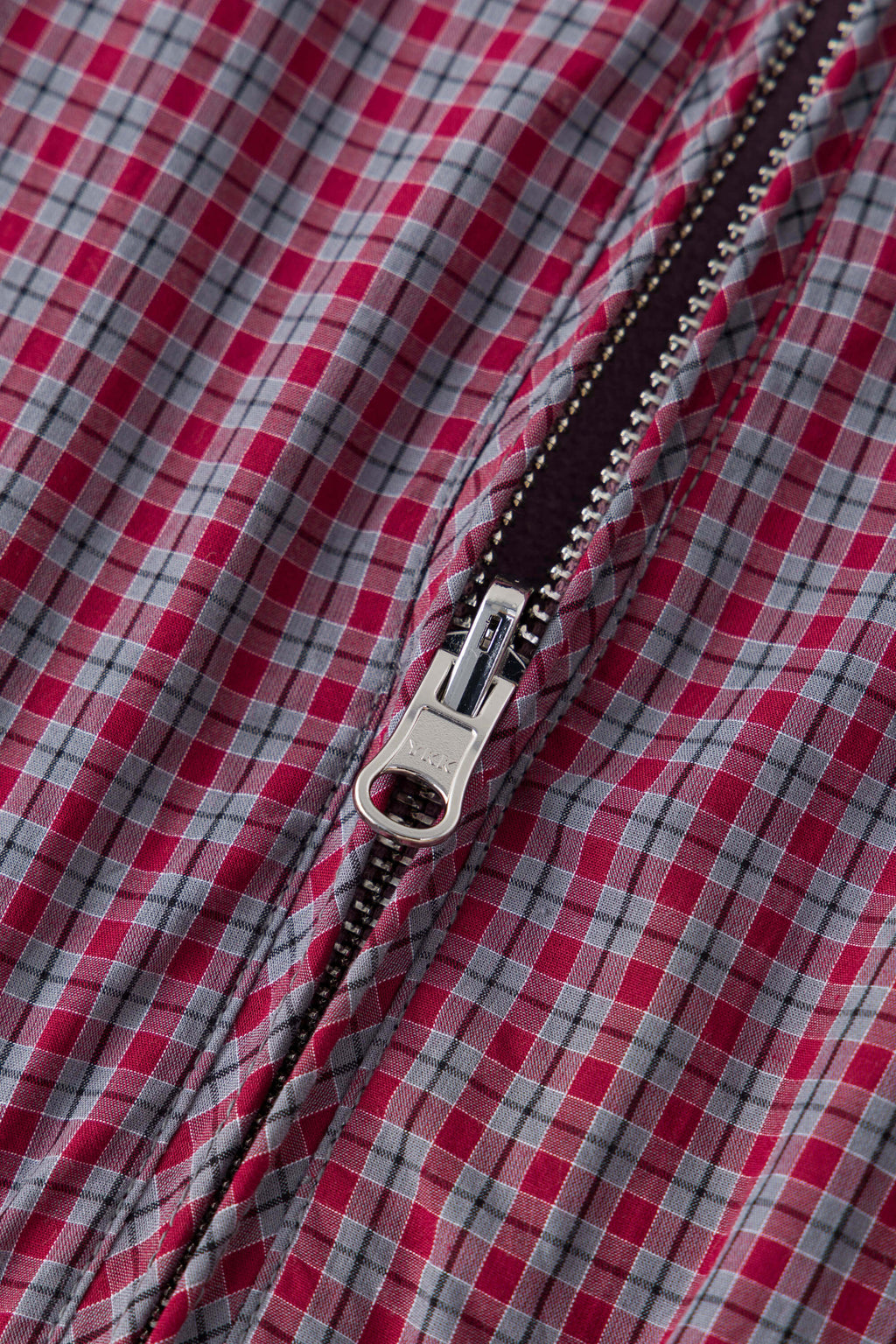 Reversible jacket with burgundy and grey micro-check pattern on one side and purple fleece on reverse