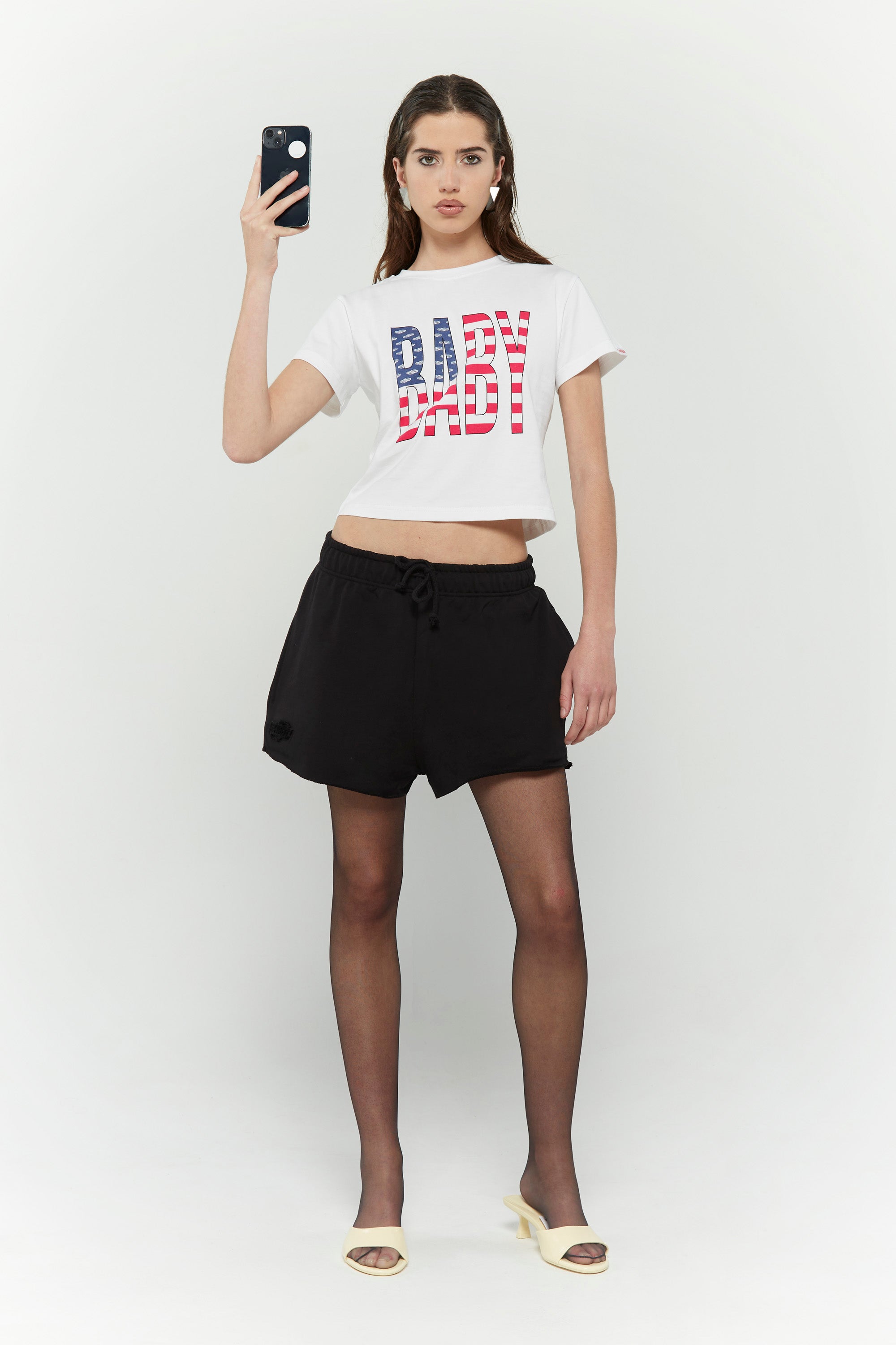 White crew neck t-shirt with the text 'BABY' digitally printed in bold letters with the American flag 
