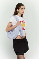 Blue striped croissant-shaped mini bag with shirt texture and adjustable sleeve handles for shoulder or crossbody wear
