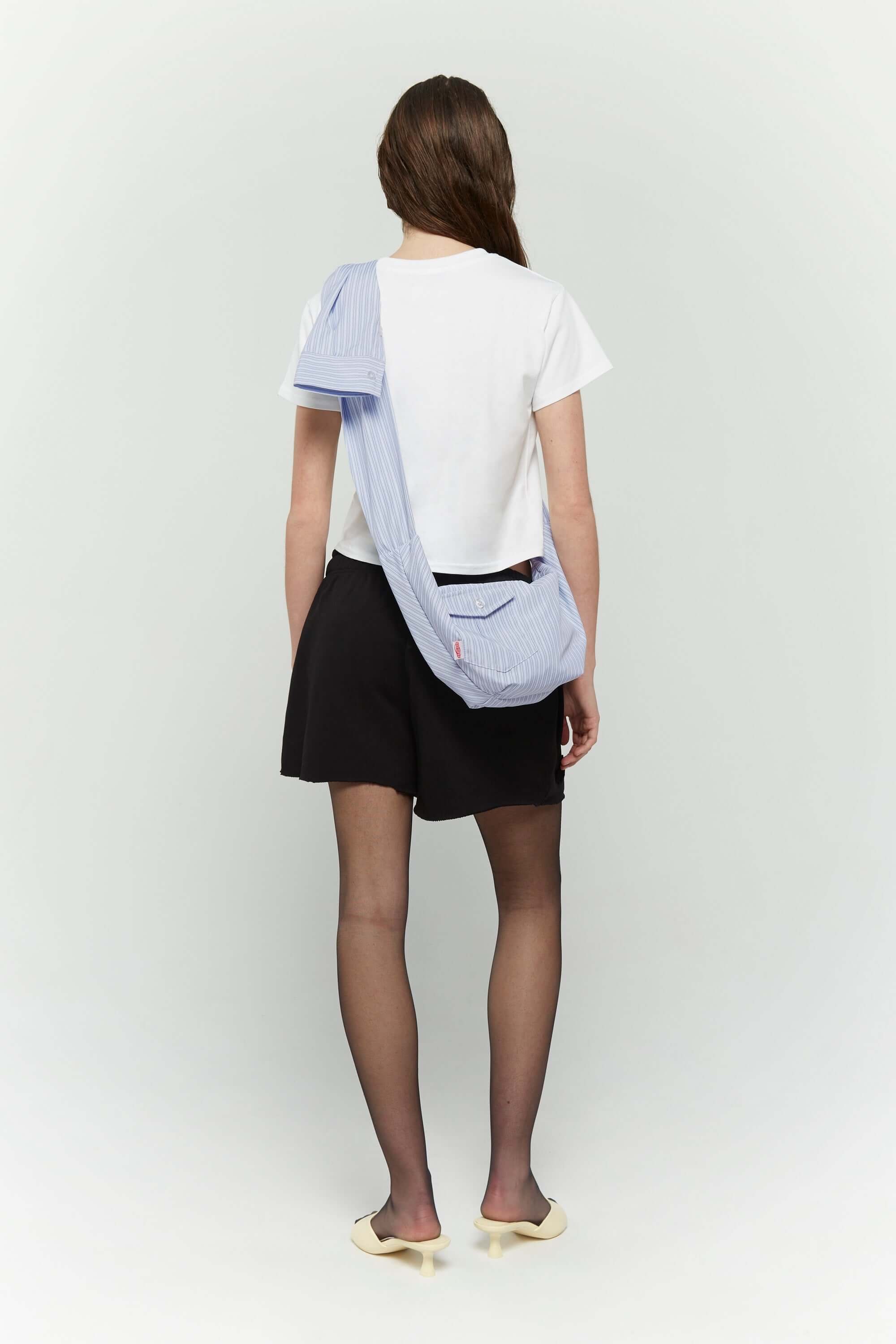 Blue striped croissant-shaped mini bag with shirt texture and adjustable sleeve handles for shoulder or crossbody wear