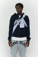 Blue striped croissant-shaped bag with shirt texture and adjustable sleeve handles for shoulder or crossbody wear, includes leather cardholder