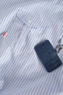 Blue striped croissant-shaped bag with shirt texture and adjustable sleeve handles for shoulder or crossbody wear, includes leather cardholder