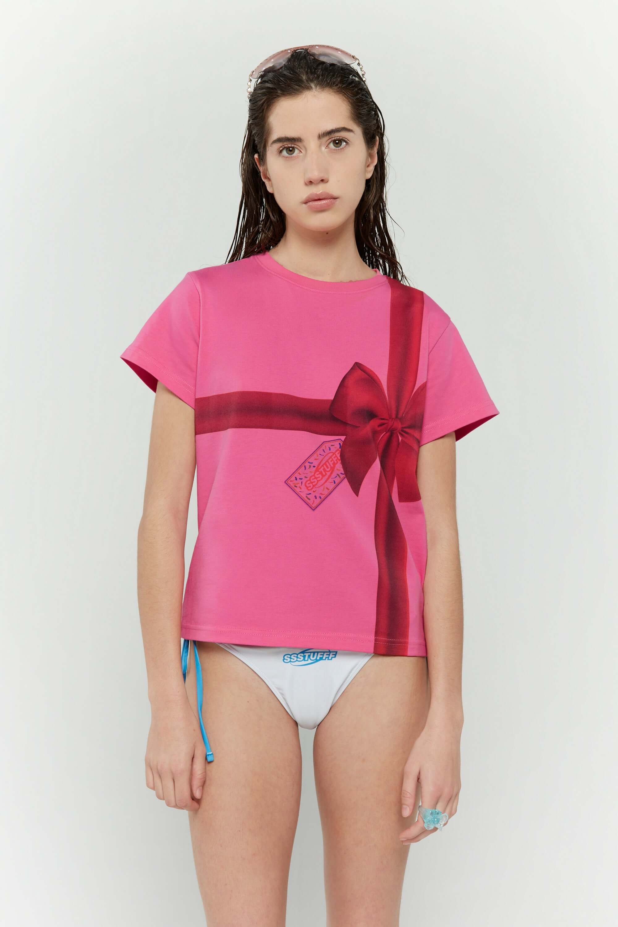 Pink t-shirt with a red ribbon graphic mimicking a present
