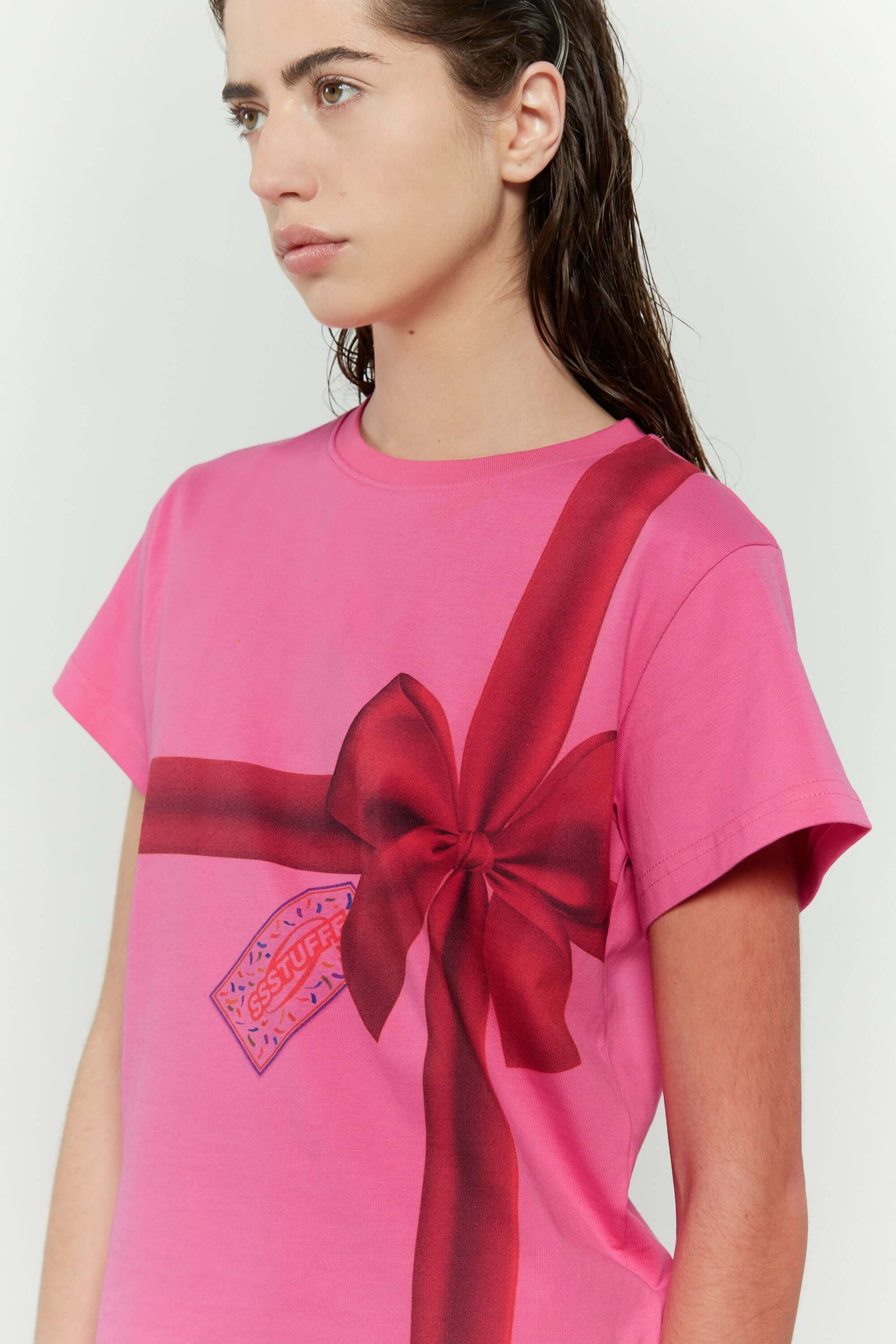 Pink t-shirt with a red ribbon graphic mimicking a present